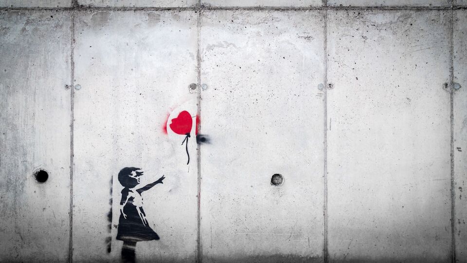Stencil art of a girl letting go of a heart-shaped balloon