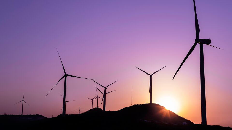 Wind turbines against a sunset